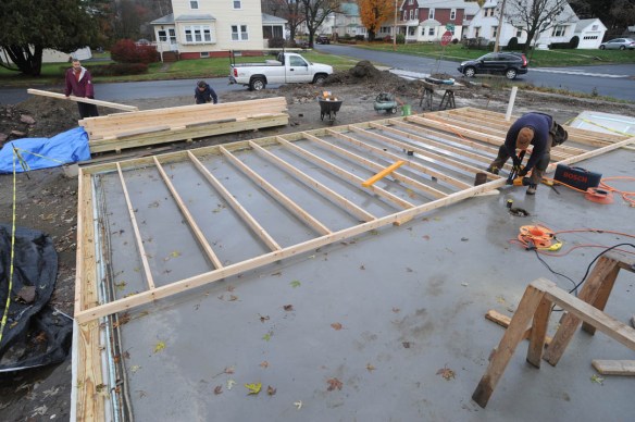 Thom working on the frame for the North wall. A delivery of lumber in the background. - picture by Thom and Beth