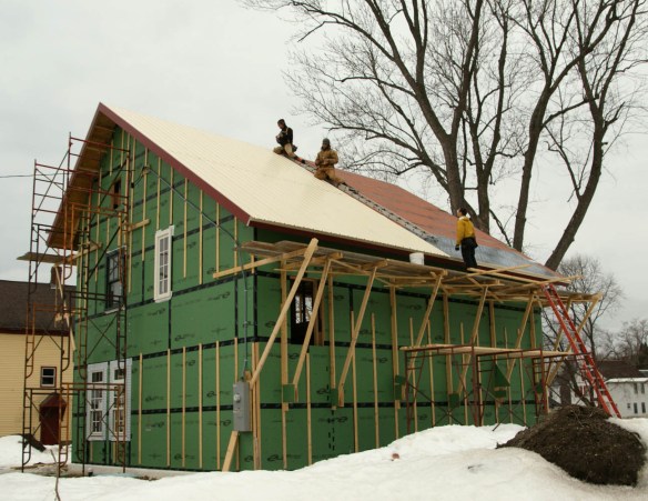Adam, Devin, and Spartan working on installing the north-facing roof