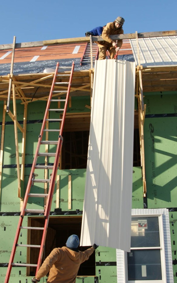 Lifting a metal panel up to the roof
