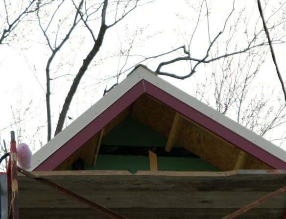 The gable peak has the metal roof wrap around the fascia boards.