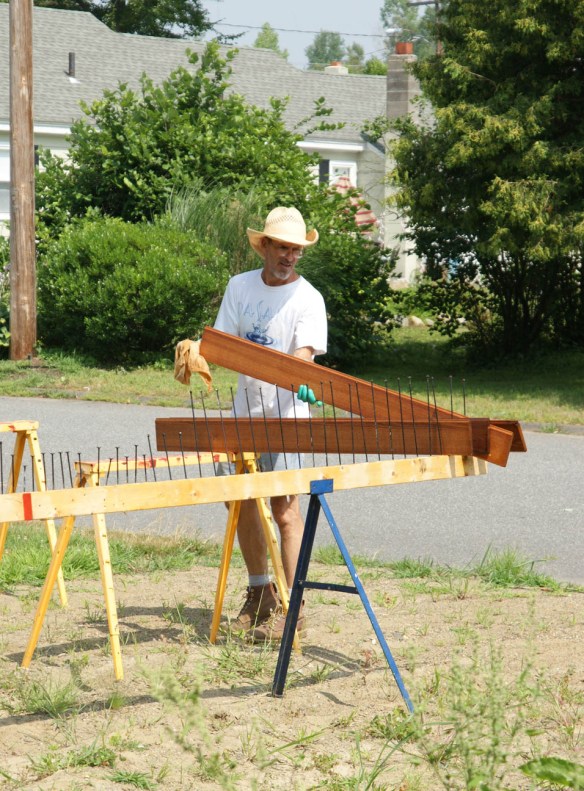 Andy putting freshly stained siding on drying rack